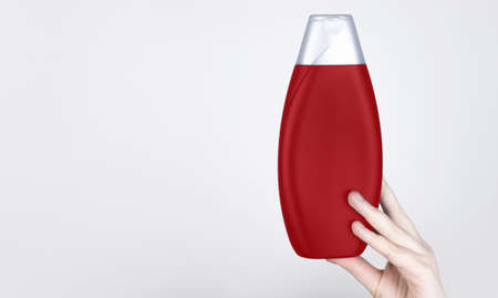 Chemical components of the shampoo. A woman's hand holds a black jar of shampoo. Place for text. Conception of the harm of chemical cosmetics or the benefits of organic chemicals for homeの写真素材