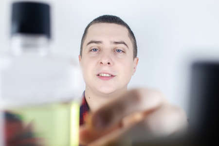 Close-up of a man in the bathroom using a mouthwash. Dental care concept. Procedure after brushing...