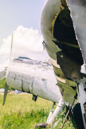 A close-up of an old wrecked passenger plane that has been decommissioned and stands for tourists. The fuselage shows traces of rust and chips. Parts of the metal structure are visible on the wingsの写真素材