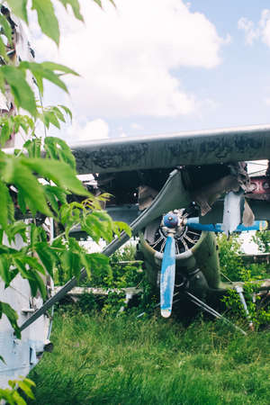 A close-up of an old aircraft engine showing rust and breakage. Visible radiator, blades, internal...