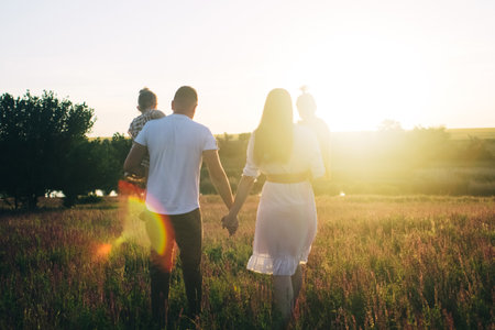 Family in the middle of a lavender field. Mom, dad and two daughters had a picnic in the steppe. Happy family in nature. Lifestyle and the concept of pleasant leisure. Sage in the sunset rays. Picnicの写真素材