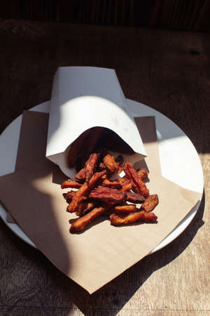 Ð¡arrot fries in a cardboard box. Vegetarian fast food dish. Grilled vegetables. BBQ cooking concept for people who do not eat meat or like vegetablesの写真素材
