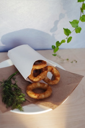 Close-up of onion rings in batter. Fried vegetables at a fast food restaurant. Vegetarian cuisine in...