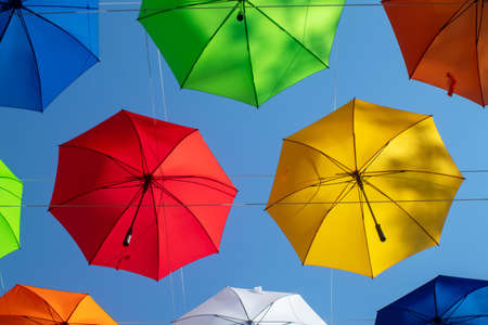 Colorful umbrellas. Bottom view. Conceptual art object. No labels or identification marks. Place for your text. Colorful background. Concept of a good mood and protection from problems. Sky is visibleの写真素材