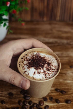 Drawings on coffee. Male and female cappuccino decoration. Hot drink in a paper cup. Picture of a chocolate mountain and Japanese cherry blossom. Food industry creativity conceptの写真素材