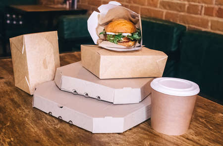 Food delivery. The girl holds paper bags with fast food in her hands. The concept of countering...