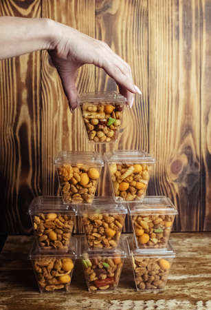 Close-up of a beer snack. Hazelnuts, cashews and peanuts with different flavors in transparent packaging. Snacks go with alcohol. Takeaway food. Conceptの写真素材