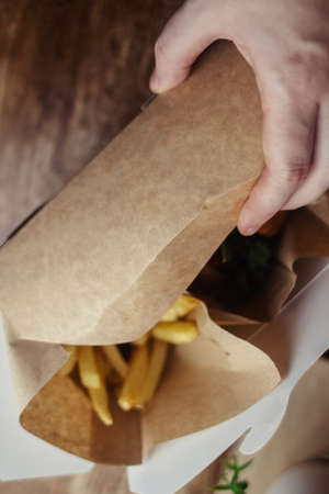 Top view of French fries. Fry dip. The concept of fast food, quick bites and restaurants for catering. Potatoes in carton and ketchup. Vertical photo.の写真素材
