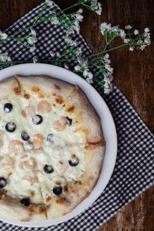 Close-up of pizza with shrimps. Seafood and vegetarian food. Italian food in restaurants and cafes. The concept of marine ingredients in meal preparation.の写真素材