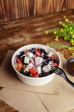 Salad in a disposable glass close-up. Healthy and fast food. Takeaway cafe. Disposable tableware for food safety. Healthy fast foodの写真素材