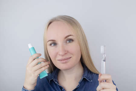 Close-up of a girl brushing teeth and look in front of a mirror. Oral hygiene. In the hands of...