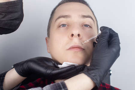 Beard growth. The master in the barber shop applies a special oil to enhance the growth of the beard and mustache. Stimulation of hair follicles on the face. Only for men. Specialist in the barbershopの写真素材