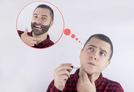 Beard growth. A man in front of a mirror rubs in a special oil that helps his facial hair grow. Enhanced mustache growth. Dream of a thick beard. Conceptの写真素材