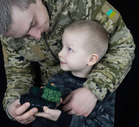 War in Ukraine. military and children. Ukrainian soldier hugs a child. Army protects country population from invaders. terrorist activities in the country. Camouflage uniform of Ukrainian militaryの写真素材