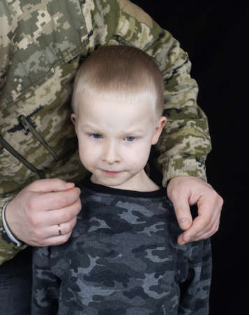 War in Ukraine. military and children. Ukrainian soldier hugs a child. Army protects country population from invaders. terrorist activities in the country. Camouflage uniform of Ukrainian militaryの写真素材