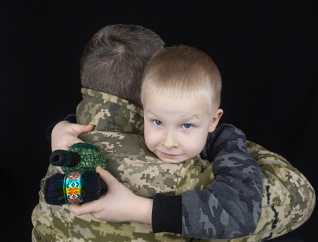 War in Ukraine. military and children. Ukrainian soldier hugs a child. Army protects country population from invaders. terrorist activities in the country. Camouflage uniform of Ukrainian militaryの写真素材
