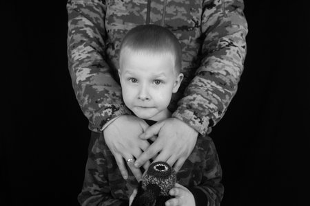 War in Ukraine. military and children. Ukrainian soldier hugs a child. Army protects country population from invaders. terrorist activities in the country. Camouflage uniform of Ukrainian militaryの写真素材