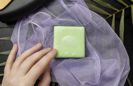 Solid hair shampoo. Composition of golden curls, soap suds, solid shampoo and comb. The concept of female care for long hair.の写真素材