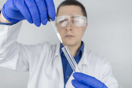 Medical laboratory assistant checks a test tube with sperm. spermogram. male fertility test. Semen in a test tube. reproductive system check. Donor suitability test for artificial inseminationの写真素材