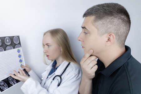 Epileptologist examines patient MRI and electroencephalogram. Concept treating epilepsy and helping...