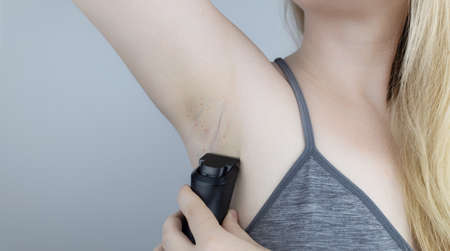 Armpit rash. Underarm skin irritation. Blonde girl shows irritation on the skin after using a razor, trimmer, deodorant or antiperspirant. Allergy or irritation. Acne or red spotsの写真素材