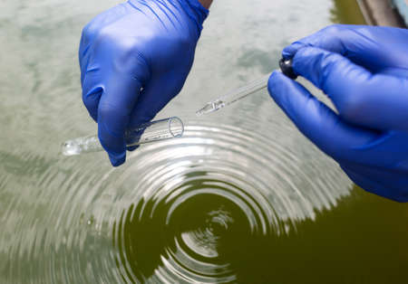 water sample. treatment facilities. Quality control of water that has been purified and processed. The laboratory assistant collects material for research. Liquid in a test tube. Sewage treatmentの写真素材