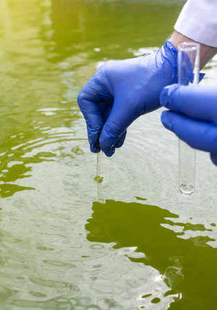water sample. treatment facilities. Quality control of water that has been purified and processed. The laboratory assistant collects material for research. Liquid in a test tube. Sewage treatmentの写真素材