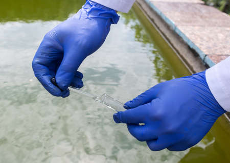 water sample. Bacterial control of pool water. Checking the amount of algae, harmful substances and chemicals. Laboratory study of water from artificial reservoirs. Taking liquid into a test tubeの写真素材
