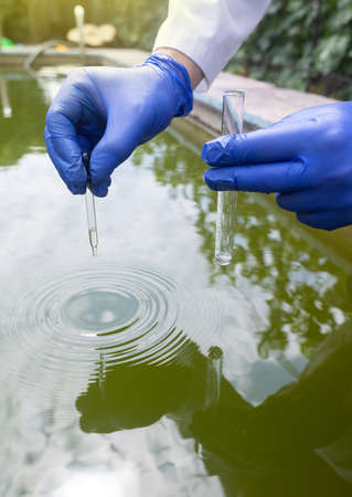 water sample. Bacterial control of pool water. Checking the amount of algae, harmful substances and chemicals. Laboratory study of water from artificial reservoirs. Taking liquid into a test tubeの写真素材