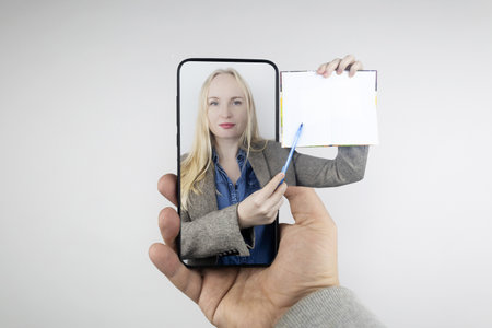 concept. Hand with a notepad pops out of screen. Girl in suit points to notebook with pen. Distance...