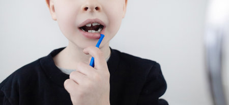 Dentistry and orthodontics. Interdental brush. A blond boy shows a brush for cleaning the...