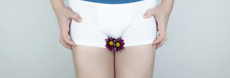 Prostatitis, inflammation of the bladder, cystitis, oncology, male problems, testicular cancer. Man in white shorts with concept symbols. Cutting during urination and pain. Man in white underwearの写真素材