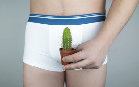 Prostatitis, inflammation of the bladder, cystitis, oncology, male problems, testicular cancer. Man in white shorts with concept symbols. Cutting during urination and pain. Man in white underwearの写真素材