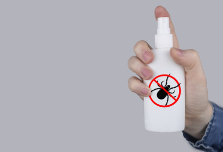 Tick repellent. insect protection. Girl holds a spray on a white background that will protect against ticks. Repelling blood-sucking insects.の写真素材
