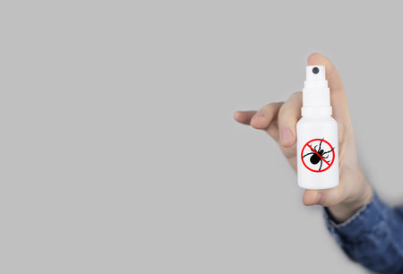 Tick repellent. insect protection. Girl holds a spray on a white background that will protect against ticks. Repelling blood-sucking insects.の写真素材
