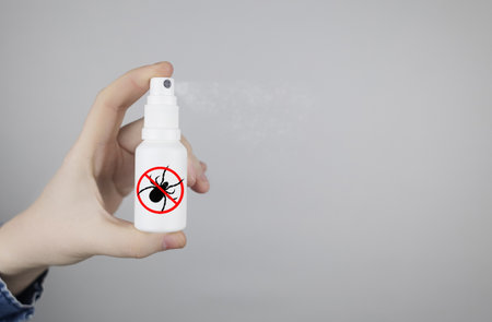 Tick repellent. insect protection. Girl holds a spray on a white background that will protect against ticks. Repelling blood-sucking insects.の写真素材