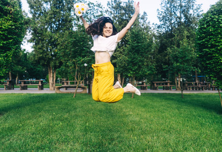 Happy girl jumped up with a bouquet of daisies. The concept of the relationship between partners....