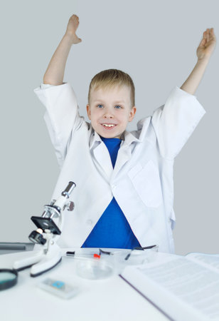 Child chemist. Teacher shows a visual experiment. A science mentor teaches an experimental approach. Microscope, petri dish, pipettes, books. Practical work in chemistry or physics. Laboratory workの写真素材