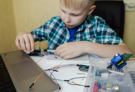 Programming for children. The boy is studying online at a robotics school for programming courses....