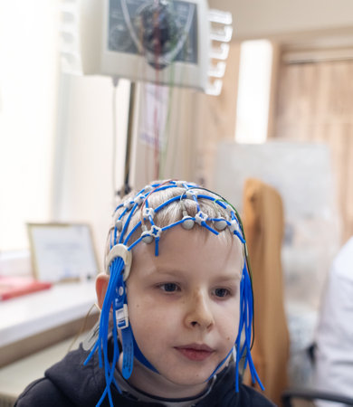 A boy's brain is examined on an EEG machine. Electroencephalogram is performed in a hospital laboratory to detect neurological diseases. Encephalogram for childrenの写真素材