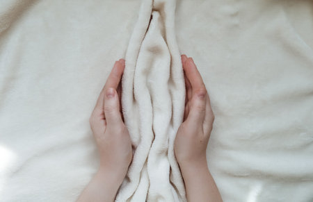 Female hands hugging folds of soft tissue in the shape of the labia, vagina and vulva. The concept of women's intimate health, prevention of gynecological diseasesの写真素材