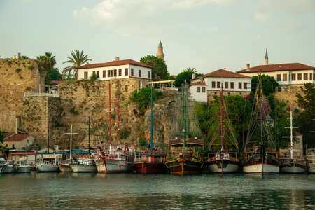 Beautiful yachts and touristic boats in the marina, port of Antalya old town Kaleici, Turkey. Old historical stone castle wall on the background. Stock image.のeditorial素材