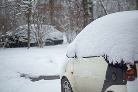 Small car covered with snow in a winter day.の写真素材