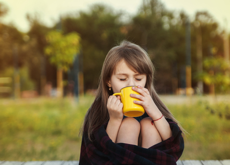 Cute little girl in the autumn park.の写真素材