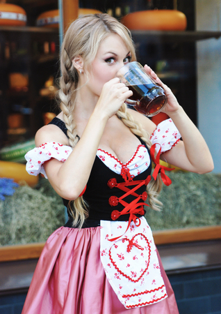 Blond woman with beer in Octoberfest dress.の写真素材