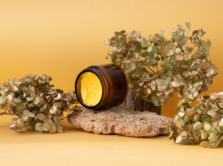 Cosmetic bottle containers with product on stone and yellow background. Cosmetic concept.の写真素材