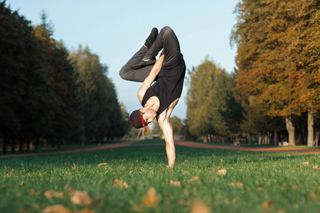 Dancer standing on hands in the parkの写真素材
