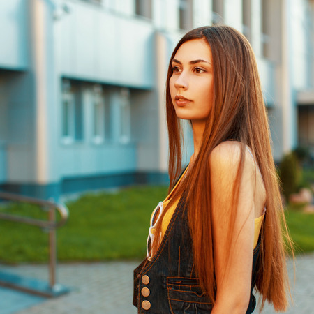 Beautiful brunette woman with long hair near the modern building.の写真素材