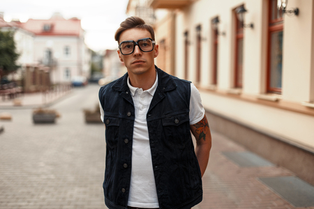 Handsome young man with glasses and jeans clothes in the cityの写真素材