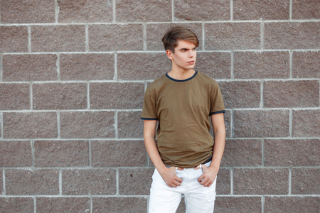 Stylish handsome young man in a T-shirt stand on a summer dayの写真素材